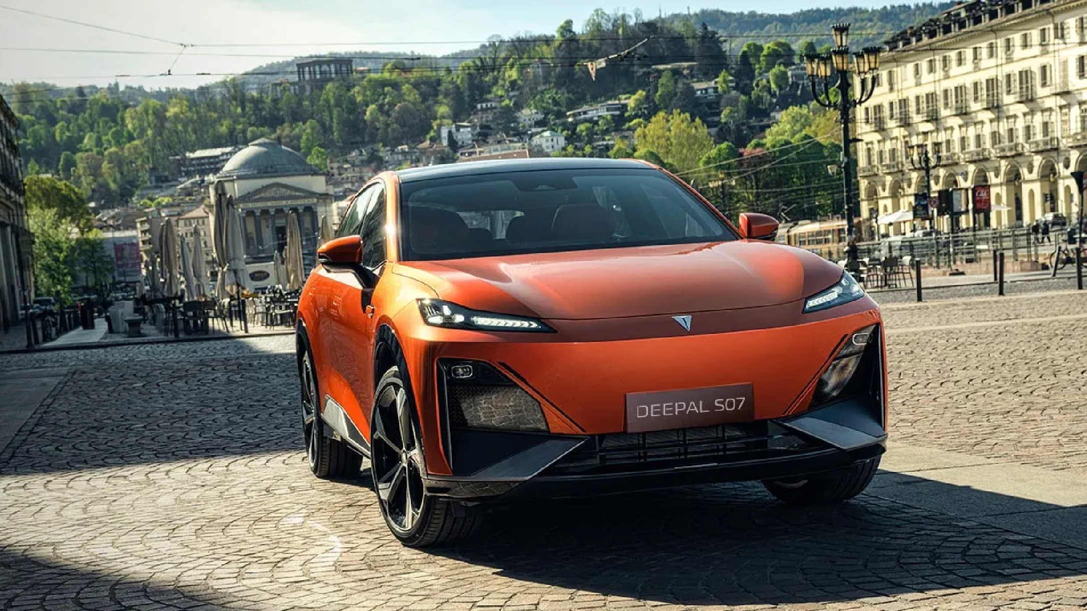 SUV hibrido eléctrico Deepal S07 color naranja siendo conducido por calles empedradas.